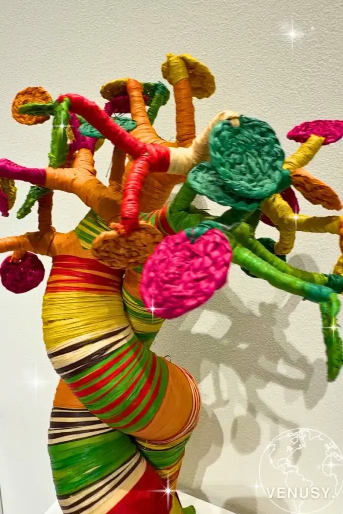 大阪万博コモンズDに展示された、カラフルな糸で装飾されたアートツリーのオブジェ