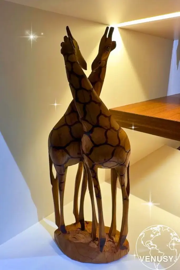 大阪万博コモンズDに展示された、木の温もりあふれるキリンの木彫りオブジェ。