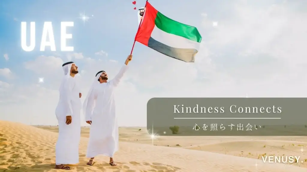 大阪・関西万博 UAE館｜砂漠の中でUAEの国旗を掲げる男性たちと、旗にひょっこり登場するキャラ。優しさと笑顔を象徴するようなユニークな演出のドバイ風景。