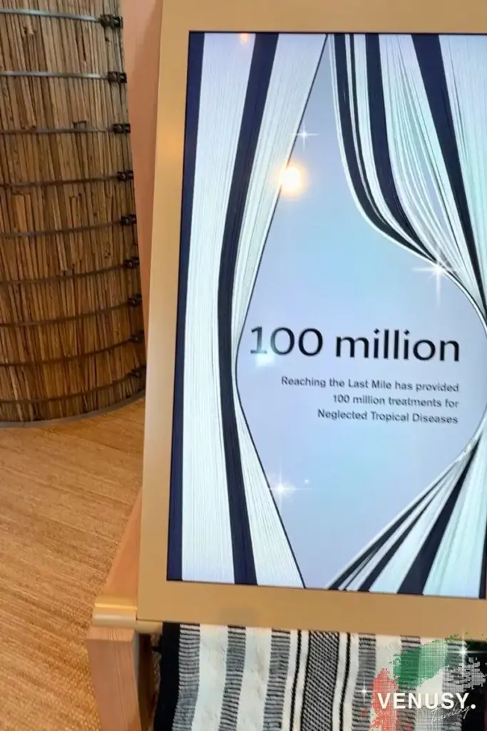 大阪・関西万博 UAE館｜UAEパビリオンの中で『100 million』と表示された展示モニター。背景には織物のような模様とテキストが表示されている。