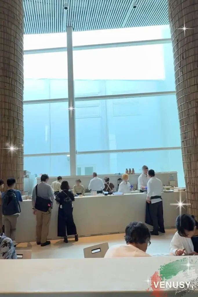 大阪・関西万博 UAE館｜白を基調とした、洗練されたUAEパビリオン内のカフェエリアと並ぶ来場者の様子。