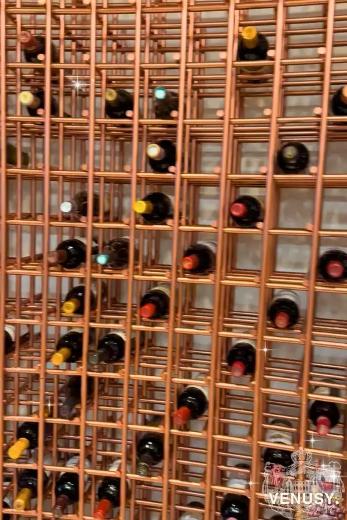 大阪・関西万博モナコ館ワインバーの銅色ワインラックに並ぶワインボトルのディスプレイ | Copper wine bottle display shelf at Monaco Pavilion wine bar – Expo 2025 Osaka