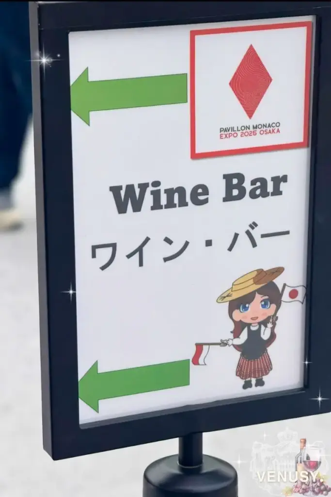 大阪・関西万博モナコ館ワインバーの案内看板(日本とモナコの旗を持ったキャラクター付き) | Cute wine bar sign at Monaco Pavilion – Expo 2025 Osaka