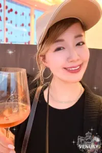 大阪・関西万博2025モナコ館でロゼワインを楽しむ女性。赤いアートが浮かぶテラス席のラグジュアリーな空間で乾杯。
