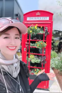 大阪万博の暑さ対策コーデ。SUOと冷タオルを併用した首元スタイルでEXPO2025イギリス館の前の赤いテレフォンボックス前で撮影したヴィナぽ♡。SUOクールリングの下から冷タオルが少し飛び出している、リアルな失敗エピソード付きファッションショット。