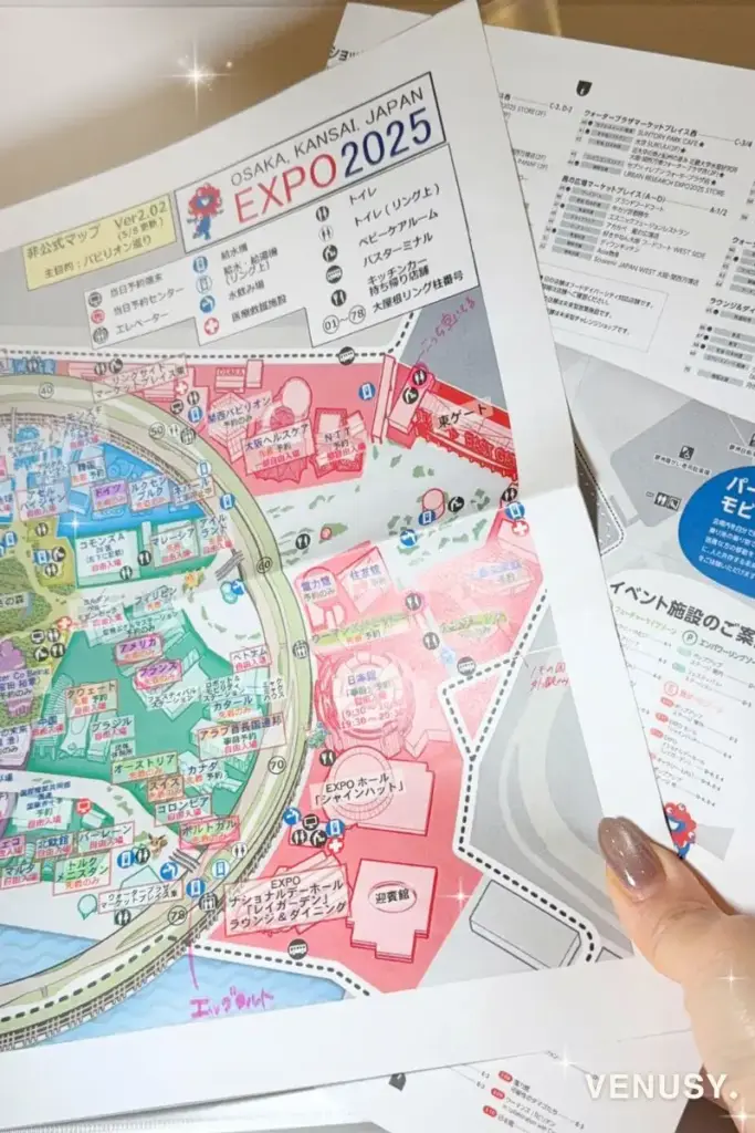 夏の万博おすすめ持ち物番外編③として、EXPO2025大阪・関西万博の公式マップと非公式マップを手に持っている写真。現地での移動や施設確認に便利な印刷資料。