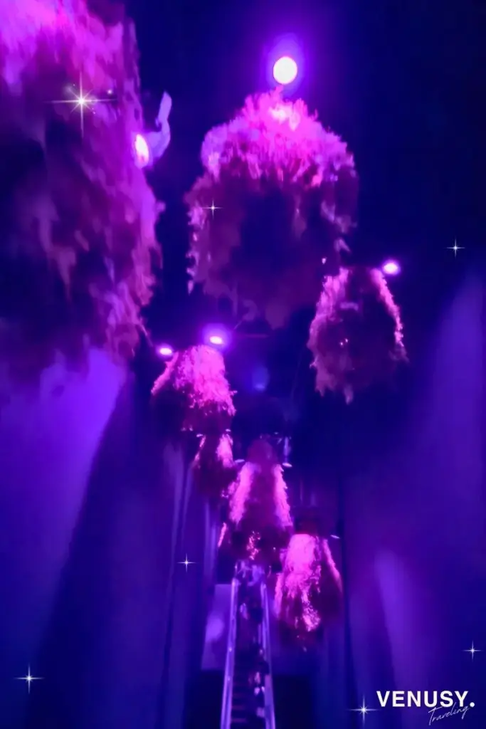 大阪万博フランス館の館内で、紫色の光演出に包まれながら幻想的に移動するエスカレーターの様子