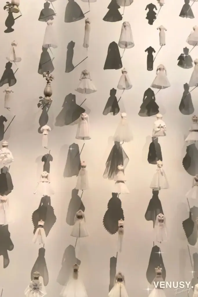 大阪万博フランス館ディオールの正面から見た壁一面のミニチュアドレス展示